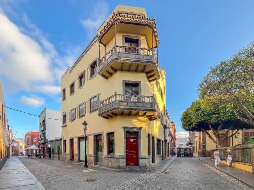 a yellow building with a balcony on a street at Casa Libelvik en pleno centro Galdar con Terraza in Gáldar