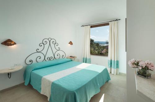 a bedroom with a blue bed with a window at Residence Il Mirto in Palau