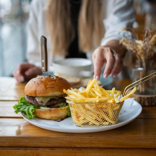 a plate with a hamburger and fries on a table at Amenity Hotel & Resort Lipno in Lipno nad Vltavou