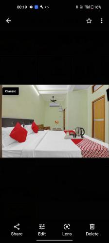 a picture of a bedroom with a bed with red pillows at Hotel khushboo Regency in Deoria