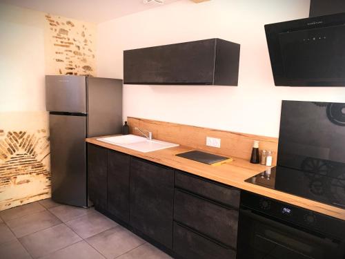 une cuisine avec un évier et un réfrigérateur dans l'établissement L'écureuil, à Châteauneuf-sur-Loire