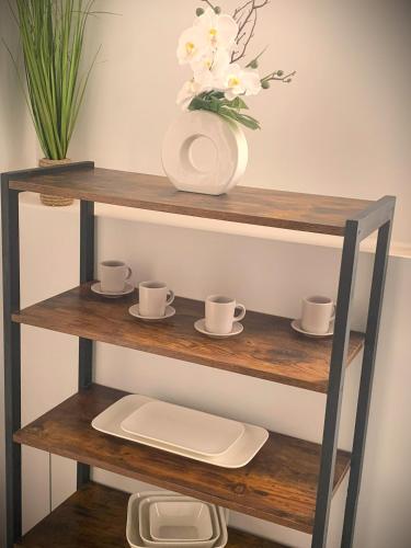 une étagère avec un vase et des tasses dessus dans l'établissement L'écureuil, à Châteauneuf-sur-Loire