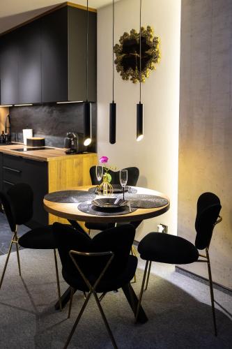 a dining room with a table and chairs in a kitchen at Apartament z prywatnym jacuzzi z widokiem na góry 109 KRAS RESORT in Szklarska Poręba