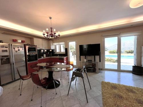 a living room with a table and a kitchen at Bella Vista pool Villas in Anavissos in Barbaliáki