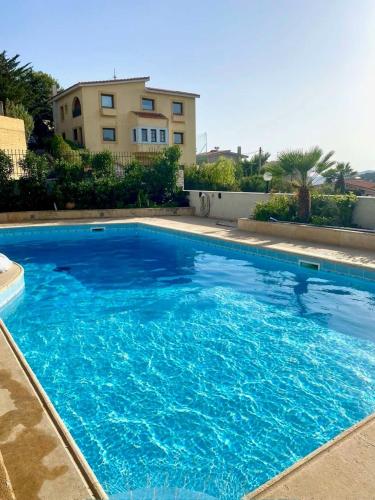 a large blue swimming pool in front of a house at Bella Vista pool Villas in Anavissos in Barbaliáki