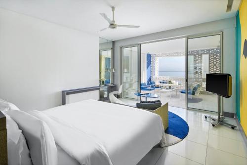 a bedroom with a large white bed and a tv at Sofitel Tamuda Bay Beach And Spa in M'diq