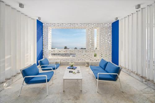 a living room with blue chairs and a table at Sofitel Tamuda Bay Beach And Spa in M'diq