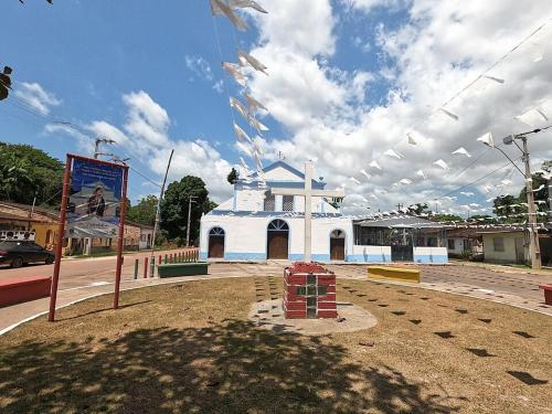 a white building with flags in front of a street at Pousada Recanto do Sabiá in Barcarena