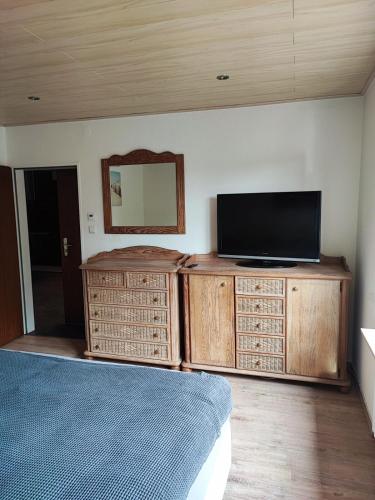 a bedroom with a flat screen tv and a bed at Ferien - und Monteurwohnung am Freibad in Büren