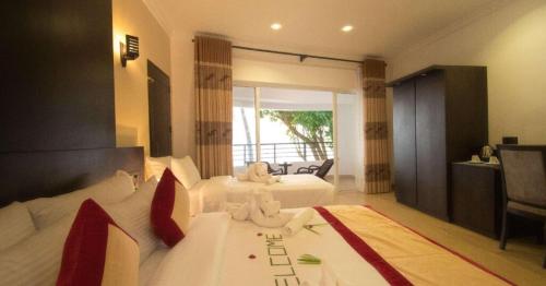 a hotel room with two beds and a balcony at Manara Beach Resort in Bentota