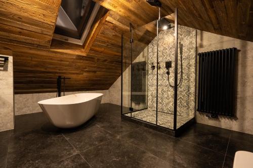 a bathroom with a tub and a glass shower at LUNA Luxury Apartments - Adults Only - sauna, jacuzzi in Szklarska Poręba