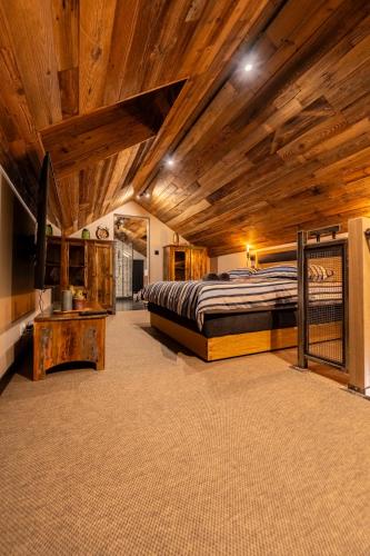 a large bedroom with a bed and a wooden ceiling at LUNA Luxury Apartments - Adults Only - sauna, jacuzzi in Szklarska Poręba