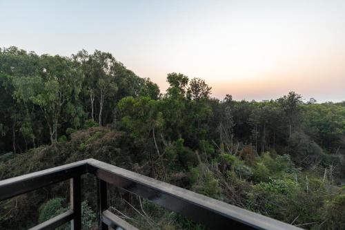 a view of the forest from a deck at Mistyblue Suites in Bengaluru