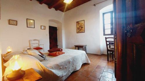 une chambre avec un lit, une table et une fenêtre dans l'établissement 1st floor apartment in 18th century character house, à Calvi