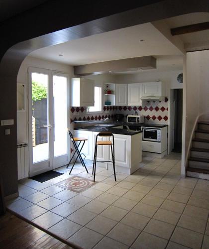 une cuisine avec des armoires blanches et une table et des chaises dans l'établissement Charming 100m2 House in Croix-Chapeau, 15mn from La Rochelle, à Croix-Chapeau