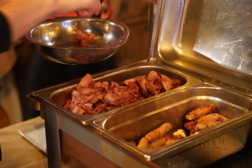 a person is preparing food in a metal container at Hôtel Le Sherpa Val Thorens in Val Thorens
