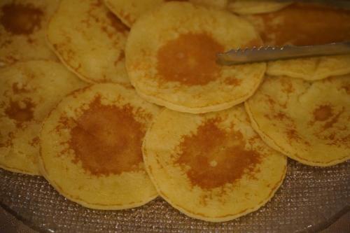 a pile of pancakes in a pan with a knife at Hôtel Le Sherpa Val Thorens in Val Thorens