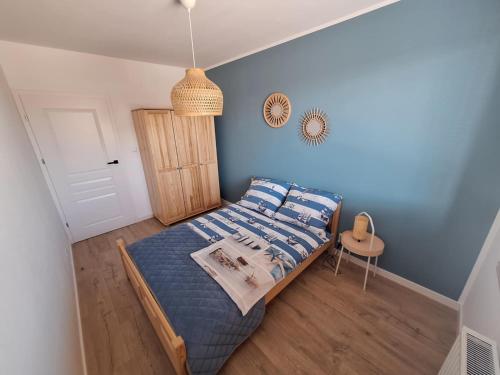 ein Schlafzimmer mit einem Bett mit einer blauen Wand in der Unterkunft SEA Apartment in Malbork