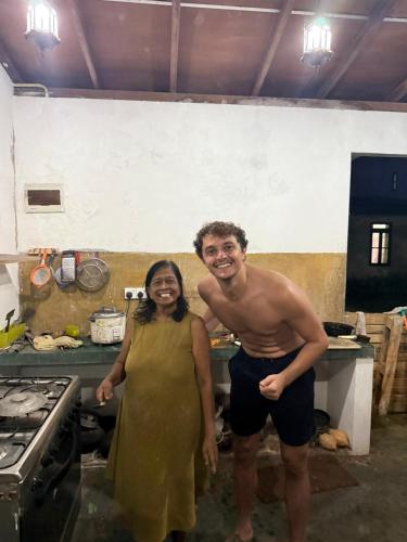 a man and a woman standing in a kitchen at New King well resort and guest house in Ahangama