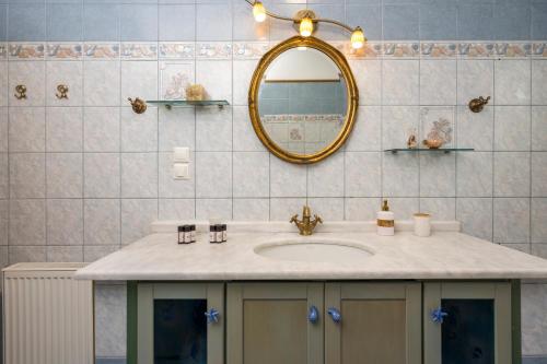 un baño con lavabo y espejo en Maison Evelyn, en Tsikalariá