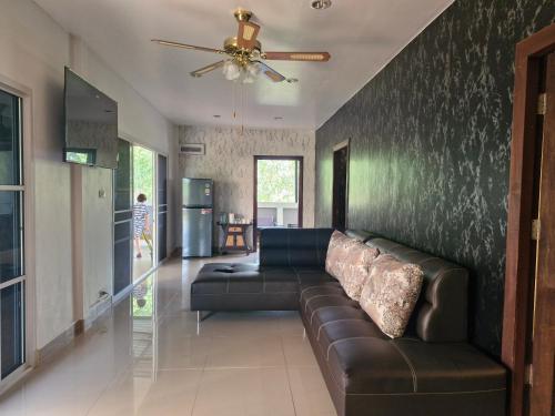a living room with a couch and a ceiling fan at 4 Palms Resort in Bang Sare