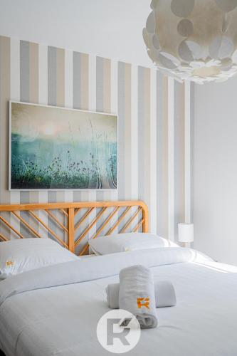 - une chambre avec un lit blanc et un lustre dans l'établissement R'Apparts La Suite D'Albert T2, à Grenoble