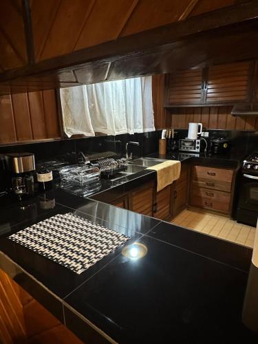 a kitchen with a black counter top and a stove at Baguio City Cabin House in Baguio