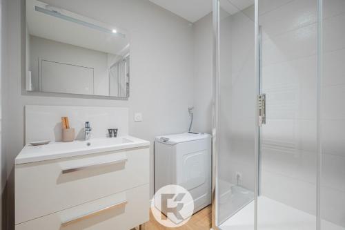 une salle de bain blanche avec un lavabo et une douche dans l'établissement R'Apparts La Suite D'Albert T2, à Grenoble