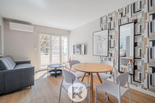 un salon avec une table et des chaises dans l'établissement R'Apparts La Suite D'Albert T2, à Grenoble
