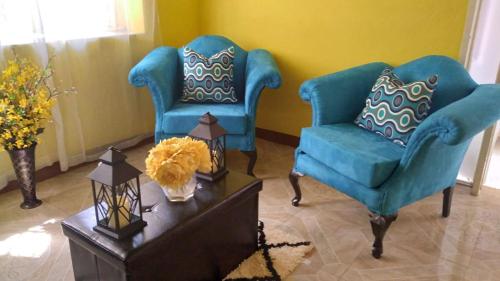 two blue chairs and a table in a living room at Charming Kingston Room for Rent - Private Entrance Full Access in Four Mile