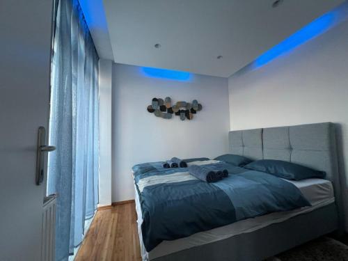 a bedroom with a bed with blue lights on it at Apartment Blue Green Virovitica in Virovitica