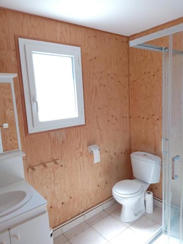 une salle de bain avec toilettes, lavabo et fenêtre dans l'établissement Marina près du Lac, à Giffaumont