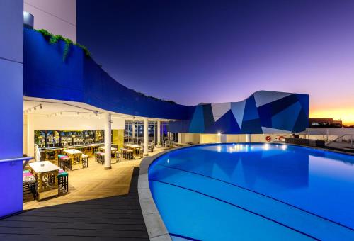 a pool on the roof of a building at night at Hotel Sky Sandton in Johannesburg