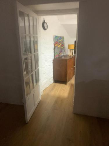 une porte ouverte menant à une chambre dotée de parquet. dans l'établissement Le Jardin Secret, à Guérande