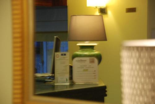 a desk with a mirror and a lamp at Hotel da Bolsa in Porto