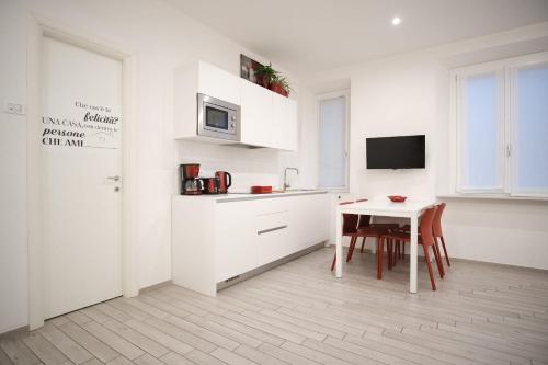 a white kitchen with a table and a microwave at Cinque Terre Bridge in La Spezia