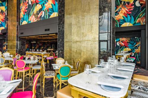 a dining room with tables and chairs and colorful walls at Hotel Sky Sandton in Johannesburg