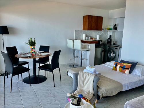 un salon avec un lit, une table et des chaises dans l'établissement studio cosy avec vue panoramique, à Luri