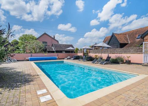a swimming pool in front of a house at Apple Mount Retreat in Lavenham