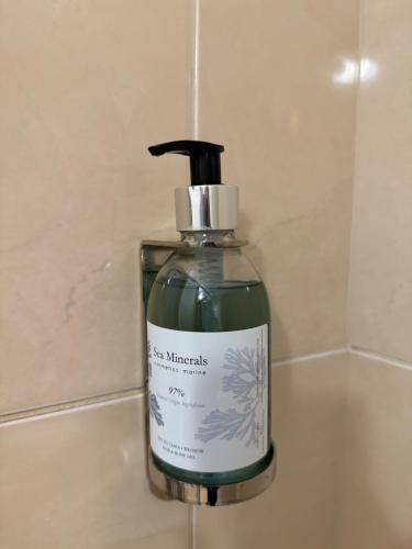 a bottle of soap sitting on a bathroom sink at Hotel Filmar in Toruń