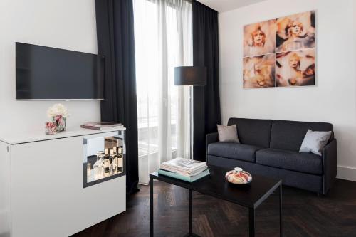 a living room with a couch and a table at Hotel AMANO Grand Central in Berlin