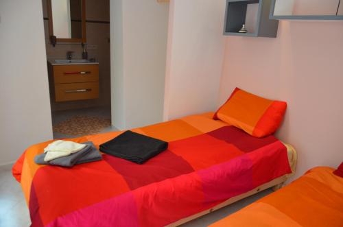 ein Schlafzimmer mit einem farbenfrohen Bett und einem Waschbecken in der Unterkunft Ryad Ayad in Marrakesch