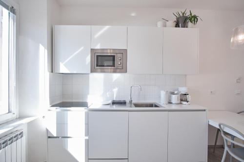 a white kitchen with a sink and a microwave at Cinque Terre Bridge in La Spezia