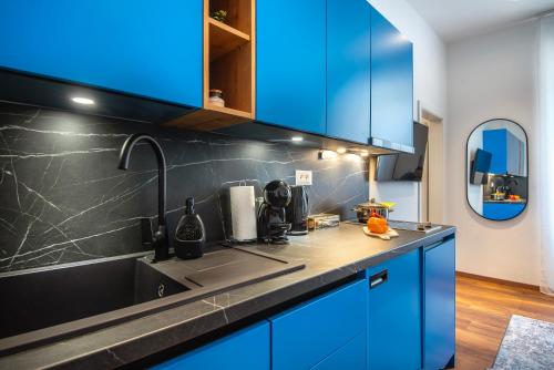 a kitchen with blue cabinets and a sink at D&A Central Luxury Apartments with FREE Parking in Pula
