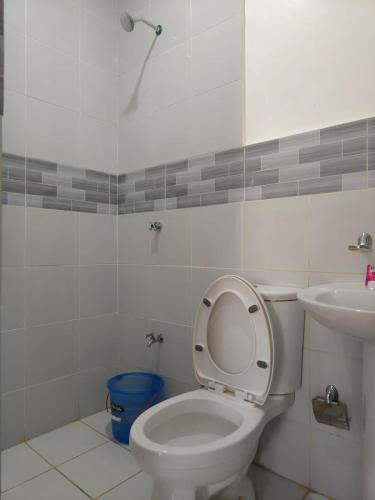 a bathroom with a toilet and a sink at Rapha's Place Joy - A in Bacolod