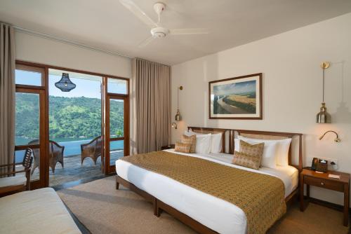 a hotel room with a bed and a balcony at Taru Villas Levita - Kandy in Gomagoda