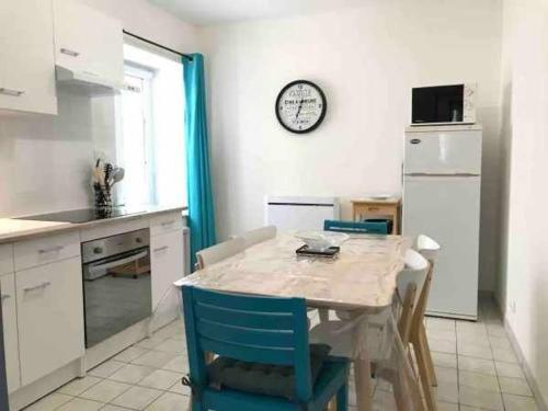 une cuisine avec une table et des chaises et une horloge au mur dans l'établissement Charmant Gîte à Neufchâteau Proche Domrémy-la-Pucelle - FR-1-589-797, à Neufchâteau