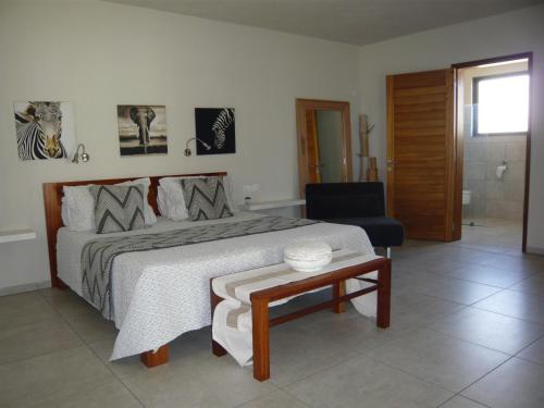 a bedroom with a bed and a chair and a table at Apartment Atrium in Grand Baie