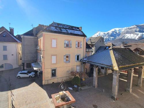une vue sur la ville avec un bâtiment et une voiture dans l'établissement Appartement T2 rénové - 2 pers - Centre St Bonnet - FR-1-393-180, à Saint-Bonnet-en-Champsaur