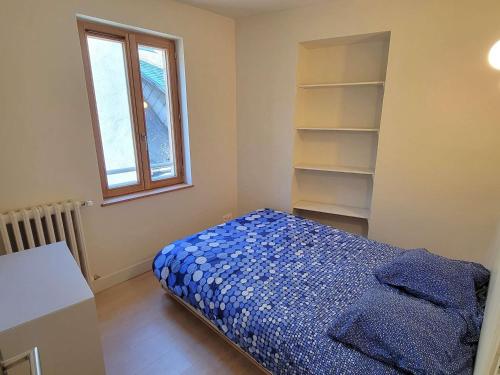 - une chambre avec un lit, une fenêtre et des étagères dans l'établissement Appartement T2 rénové - 2 pers - Centre St Bonnet - FR-1-393-180, à Saint-Bonnet-en-Champsaur